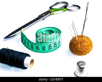 Measuring meter and sewing accessories on a white background. Yardstick. Centimeter or Inch. Needles and threads. Tailors scissors. Seamstress tool. C Stock Photo