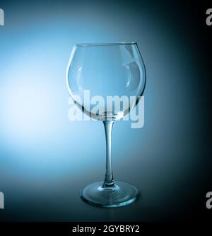 Empty wine glass with a high leg in the dark. Wine glass. Glassware for alcoholic beverages. Glassware for drinks. Transparency. Drinking establishmen Stock Photo