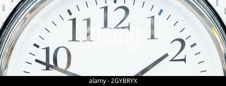 round clock with black arrows and numbers. big clock hanging on a wall. deadline,time management concept and lunch time,WAKE UP.web banner. Stock Photo