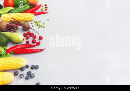 Flat lay with different vegetables, fruits, berries, nuts, spices, herbs, olive oil. Copy space area for some text. Veggies on grey concrete backgroun Stock Photo