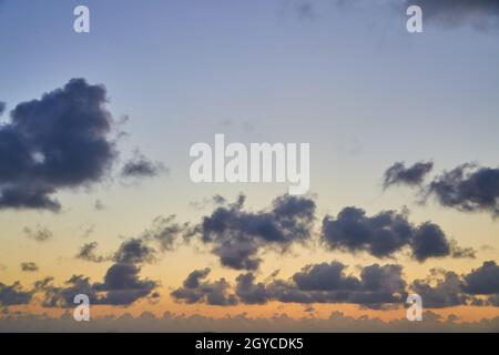 Clean sunset sky with dark spotted clouds and muted colors Stock Photo