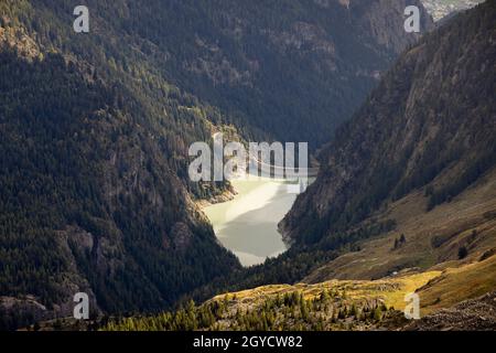 GIBIDUM DAM, NATERS, SWITZERLAND - September 22, 2017: View on the large hydroelectric power hydrodam in the middle of the pine tree covered mountaino Stock Photo
