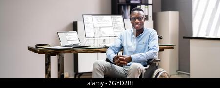 African American In Wheelchair Using Computer. Handicapped Developer Coder Stock Photo