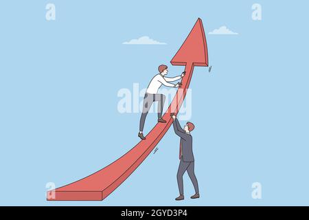 Teamwork, development, collaboration in business concept. Two young businessmen in suits putting huge red arrow up as symbol of success and progress t Stock Photo