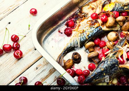 Baked mackerel with cherry sauce.Fish filled with berries in baking dish Stock Photo