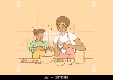 Cooking together and spending time with children concept. Young smiling beautiful African American woman mother and her daughter cooking in kitchen to