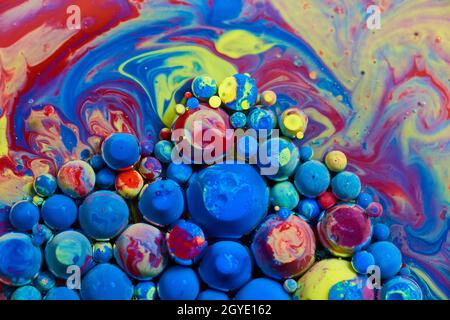 Cluster of acrylic paint orbs floating on rainbow surface Stock Photo