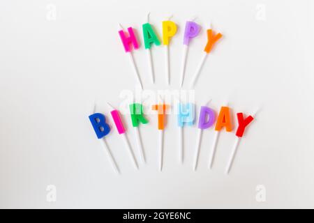 Colorful candles with the inscription Happy Birthday isolated on a white background. Holiday and surprise concept Stock Photo