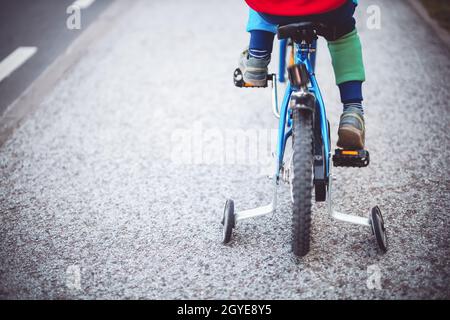Little boy on the bicycle on the road in the city. Concept of the cycling training and bike adventure. Stock Photo