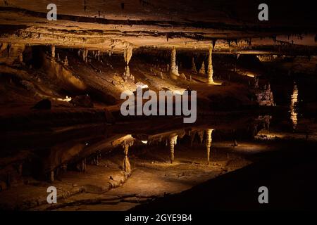 Large reflective pond that looks like a mirror in cave with stalagmites and stalactites Stock Photo