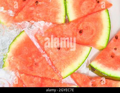 Slices of melon in water on white background. Melon close-up in liquid with bubbles. Slices of red ripe melon in water. Macro image of fruits in water Stock Photo