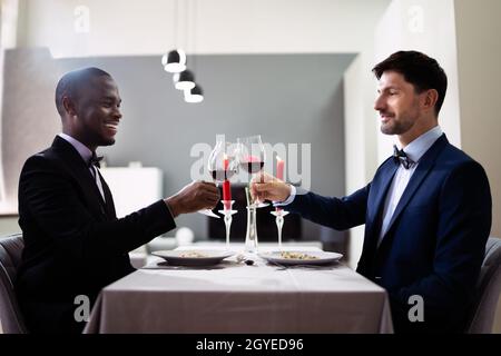 Gay Couple Having Dinner In Restaurant. People In Love Stock Photo
