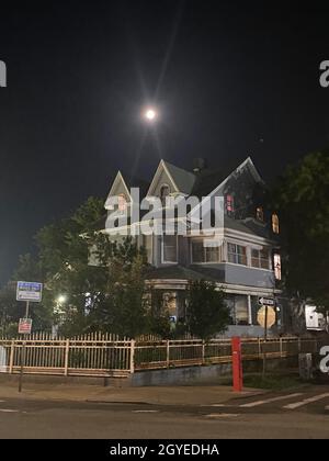 Harvest (Full) Moon, rising over a house in the Kensington neighborhood of Brooklyn, New York. Stock Photo