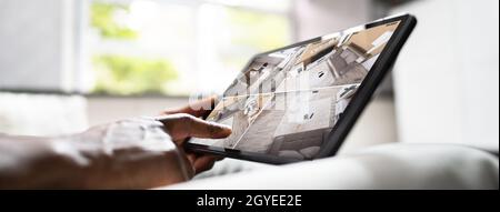 African American Using Security And Alarm System On Tablet Stock Photo