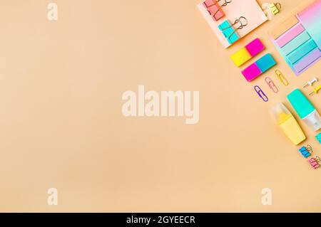 Neutral pastel beige background and school supplies, stationery accessories in top-right edge. Copy space. Top view flat lay. Education, back to schoo Stock Photo