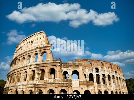 Rome, Italy. Arches archictecture of Colosseum (Colosseo) exterior with blue sky background and clouds. Stock Photo