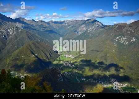 The small towns Pieve di Ledro, Bezzecca, Locca, Enguiso, Concei and Lenzumo near Lake Ledro with their surrounding mountains. View from Mount Corno o Stock Photo