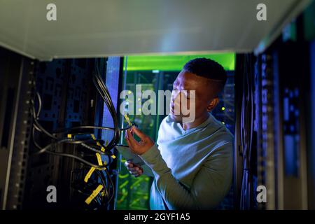 African american male computer technician working in server room Stock Photo
