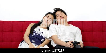Asian couple falling asleep on the sofa after finishing the photo shoot in the studio. Stock Photo