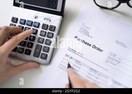 Person Hand Filling A Purchase Order Form On Desk Stock Photo