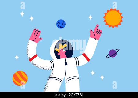 Astronaut during work in space concept. Young smiling cosmonaut in white protective suit standing levitating in space near planets and galaxies around Stock Photo