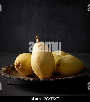 ripe green pears on a metal plate, black background, close up Stock Photo