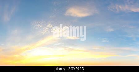 Beautiful high resolution panorama of orange and red sunset clouds in the evening sky. Stock Photo