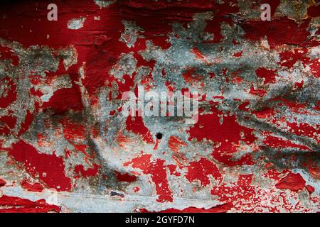 Texture of gray steel with peeling patches of red paint Stock Photo