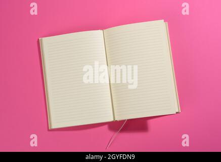 open notebook with blank white sheets on pink background, top view Stock Photo