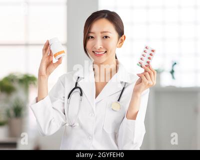 Smiling female doctor showing  pills Stock Photo