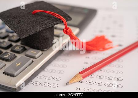 Graduation gap hat and pencil on answer sheet background : Education study testing learning teach concept. Stock Photo