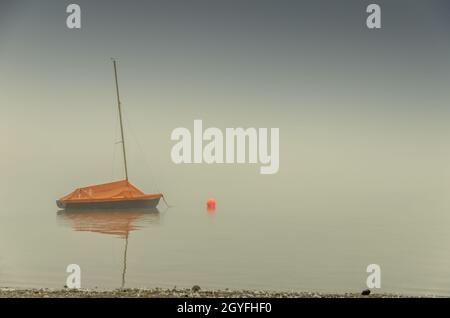 Sailboat in fog on Lake Constance. Allensbach, Baden-Wuerttemberg, Germany Stock Photo