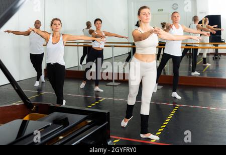 Concentrated women and men rehearsing ballet dance Stock Photo