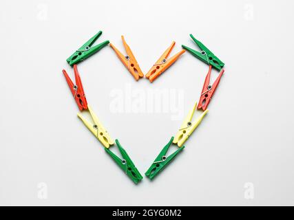Heart made of plastic clothespins on grey background Stock Photo