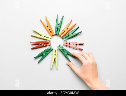 Female hand and plastic clothespins on grey background Stock Photo