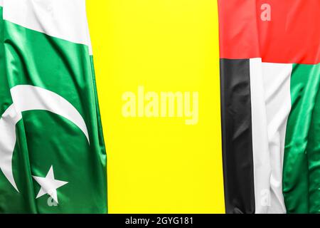 National United Arab Emirates and Pakistan flags on yellow background, closeup Stock Photo