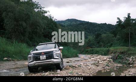 Traveling by pickup truck and camping with rooftop tent. Mitsubishi L200 Triton is parked on the stream in the forest. Amazing nature landscape Stock Photo