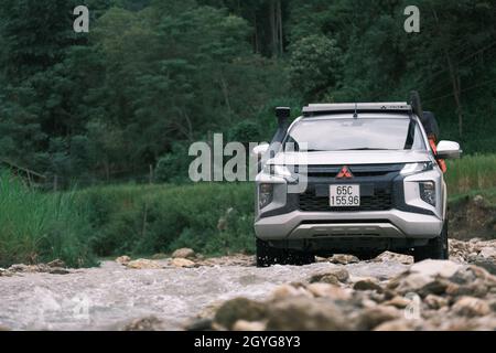 Traveling by pickup truck and camping with rooftop tent. Mitsubishi L200 Triton is parked on the stream in the forest. Amazing nature landscape Stock Photo
