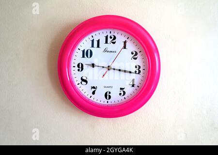 Brightly coloured wall clock with clear numerals do easy to read Stock Photo
