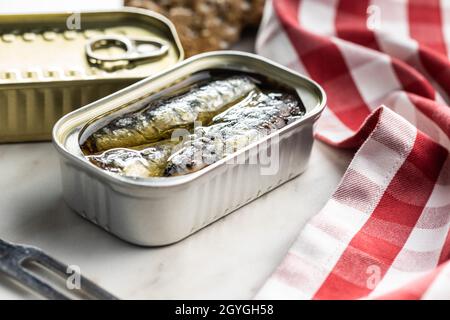 Canned sardines. Sea fish in tin can on kitchen table. Stock Photo