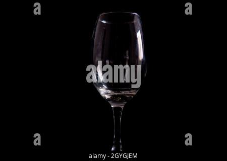 Light reflecting on empty glass goblet with black background Stock Photo