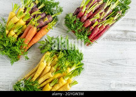 Freshly harvested colorful mini carrots on white wooden background Stock Photo