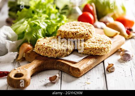 A Board With Minced Meat, Lettuce Leaves, Cherry Tomatoes, And Black 