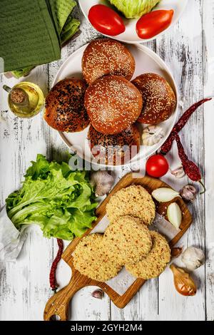 Breaded chicken cutlet with paprika and fresh hamburger buns. Homemade minced poultry cutlets with spices. Fresh lettuce leaves, tomatoes and onions. Stock Photo