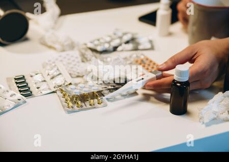 Image of various pills, cough syrup, nasal spray lying on the table. Medical treatment. Cold and flu, allergy Stock Photo