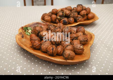 Fresh harvest walnuts with shells and water drops in wooden bowl. Walnuts details Stock Photo
