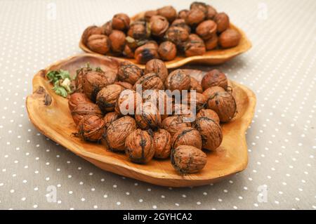 Fresh harvest walnuts with shells and water drops in wooden bowl. Walnuts details Stock Photo