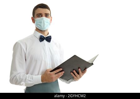 Waiter in mask holds menu, isolated on white background. Stock Photo