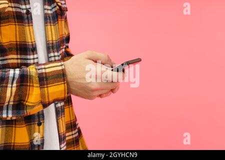 Man using phone on pink background, space for text. Stock Photo
