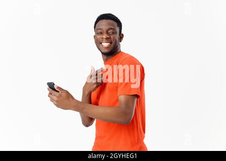 handsome guy of african appearance smiles and holds a mobile phone in his hand Stock Photo